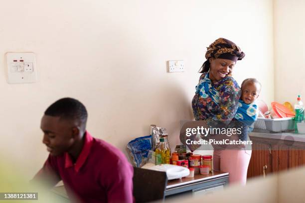 young happy mother prepares food for extended family - quarantine cooking stock pictures, royalty-free photos & images