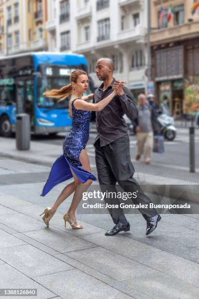multirassisches tanzpaar tanzt in madrid"u2019s gran vía straße - tango black stock-fotos und bilder