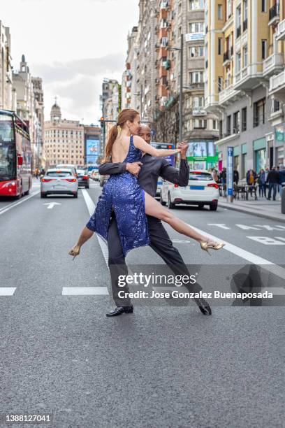 multirassisches tanzpaar tanzt über die gran via street in madrid, spanien - tango black stock-fotos und bilder