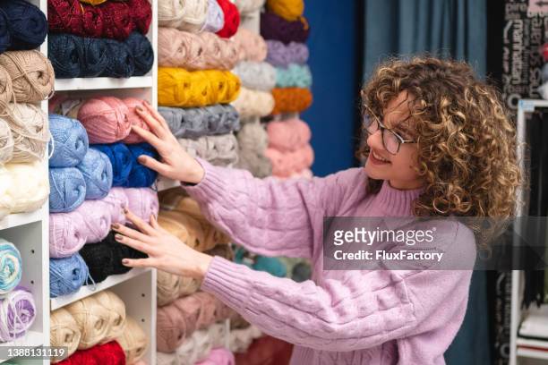 cliente femenina, eligiendo la bola de lana, en la tienda de telas - art supplies fotografías e imágenes de stock