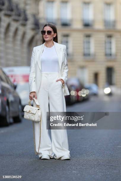 Diane Batoukina wears a white ribbed t-shirt from Anine Bing, a white latte blazer jacket from Max Mara, high waist matching white latte wide legs...