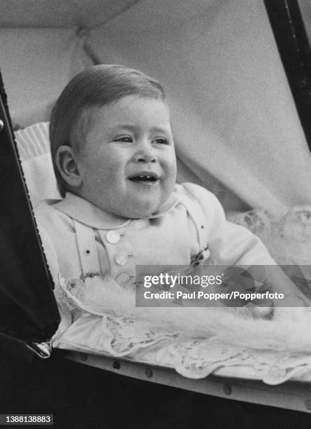 Prince Charles, infant son of Princess Elizabeth and Prince Philip, Duke of Edinburgh, seated in his pram during a walk with royal nanny Helen...