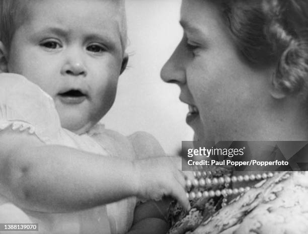 Princess Elizabeth with her young son Prince Charles in the gardens of the royal residence of Windlesham Moor in Surrey, England in July 1949.