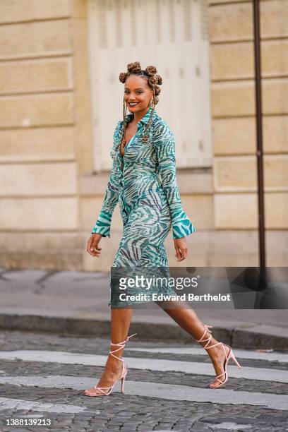 Alicia Aylies wears gold earrings, a white and dark green zebra print pattern buttoned V-neck / long sleeves / midi dress, pale pink shiny leather...