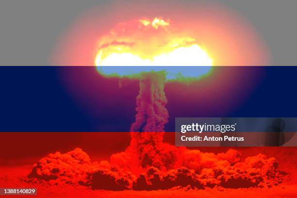nuclear explosion on the background of the flag of russia. threat of nuclear war - russische kultur stock-fotos und bilder