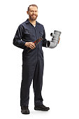 Full length portrait of a plumber holding a plastic pipe and pliers