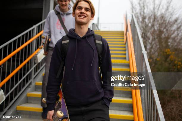 happy teenage boy with skateboard descending urban stairs - last 16 stock-fotos und bilder