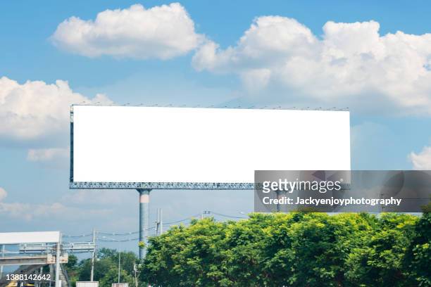 blank advertising screen against soft blue sky - billboards stock-fotos und bilder