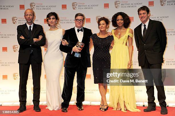 Outstanding British Film winners Tomas Alfredson, Tim Bevan, Eric Fellner and Robyn Slovo pose with presenters Berenice Marlohe and Naomie Harris in...