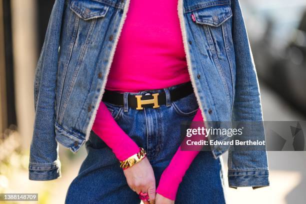 Emy Venturini wears a neon pink tutleneck / long sleeves pullover from Cos, a blue denim with white sheep interior jacket from Levis, a black shiny...