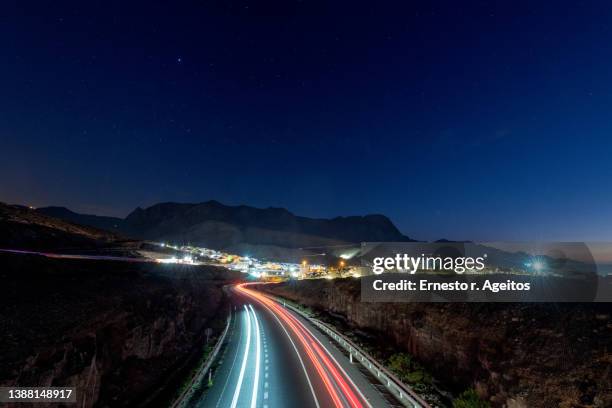 traffic light trails in a road near a town - atlantic islands fotografías e imágenes de stock