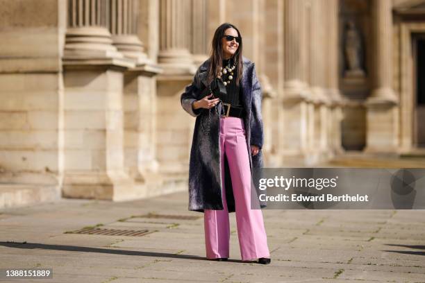 Alba Garavito Torre wears black sunglasses from Ray Ban, a black ribbed wool top, a large pearls necklace, a navy blue and white tie and dye print...