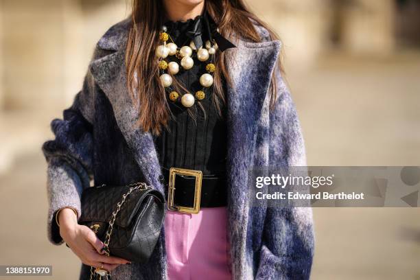 Alba Garavito Torre wears a black ribbed wool top, a large pearls necklace, a navy blue and white tie and dye print pattern fluffy long coat from...