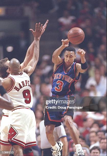 Guard John Starks of the New York Knicks pass the ball over guard Ron Harper of the Chicago Bulls at the United Center in Chicago, Illinois. The...