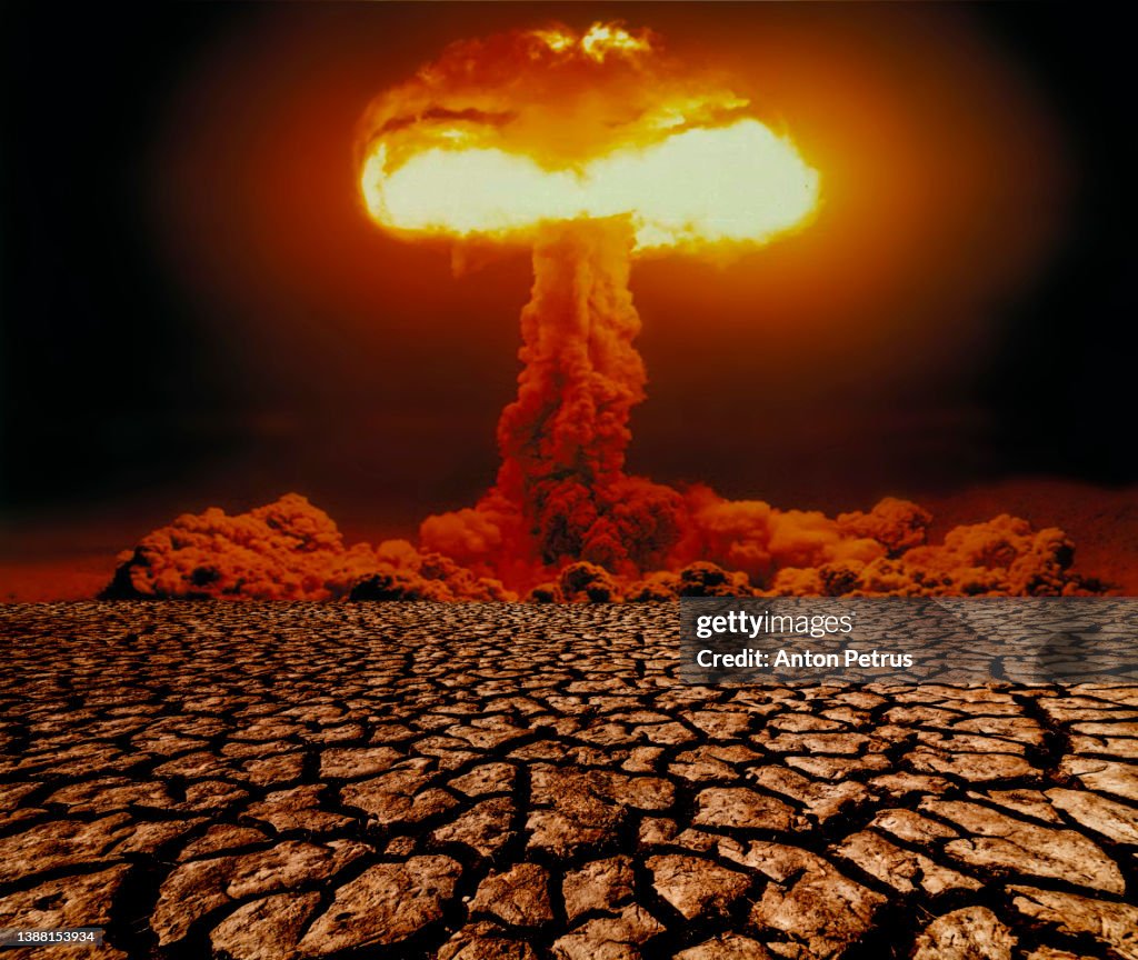 Nuclear explosion with mushroom cloud on scorched earth. Nuclear war threat concept