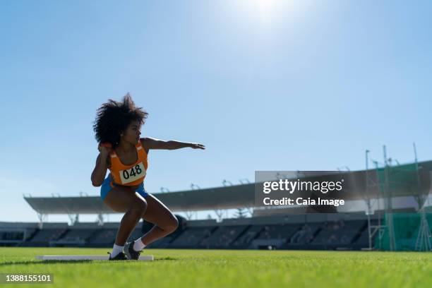 female track and field athlete throwing shot put in sunny stadium - shot put stock pictures, royalty-free photos & images