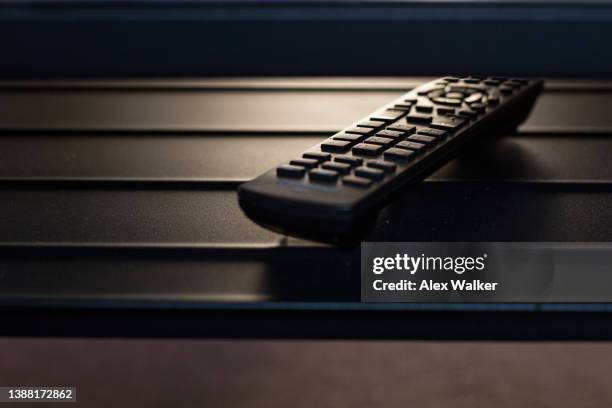 generic tv remote on textured shelf - binge watching stock-fotos und bilder