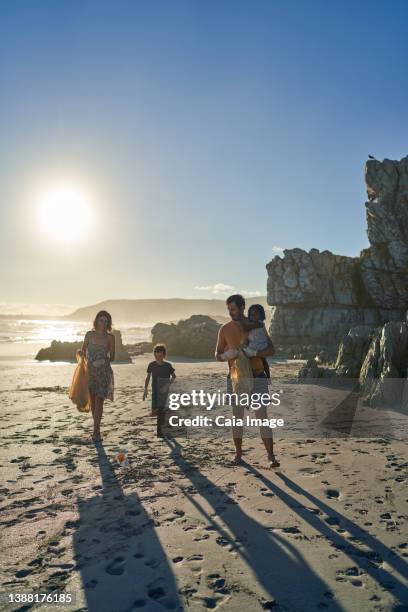 family volunteering picking up garbage on sunny summer beach - picking up garbage stock pictures, royalty-free photos & images