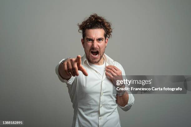 young man screaming while pointing at you - stubble stockfoto's en -beelden