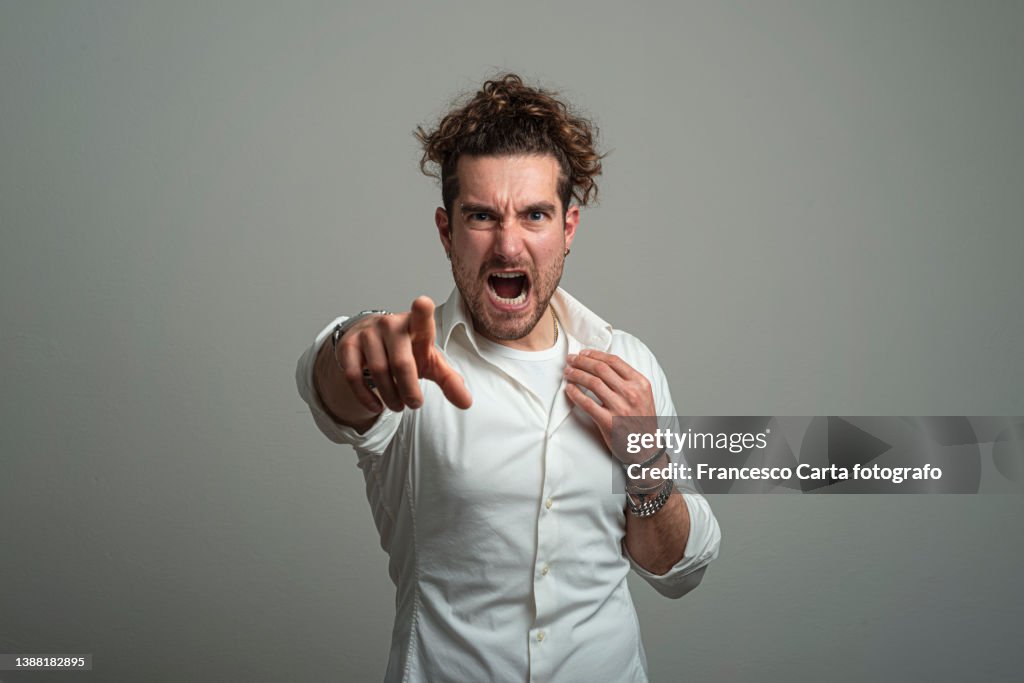 Young man screaming while pointing at you