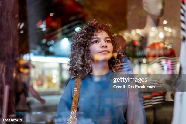 young woman looking at clothing store - shopping centre stock pictures, royalty-free photos & images