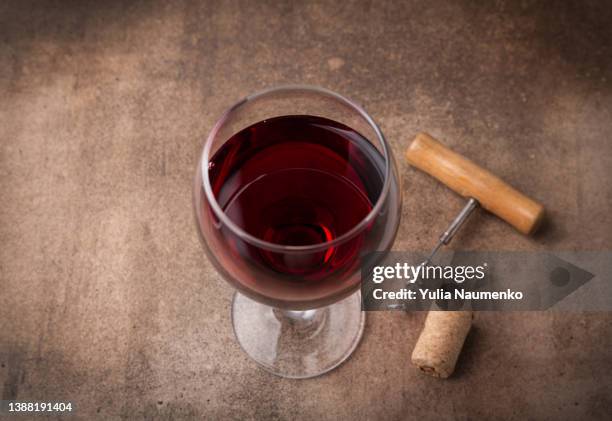 glass of red wine and bottle on dark background. - merlot stock pictures, royalty-free photos & images