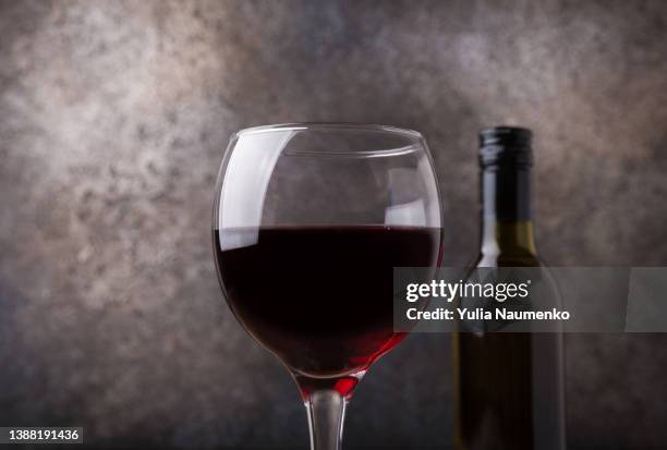 glass of red wine and bottle on dark background. - table vin stock-fotos und bilder