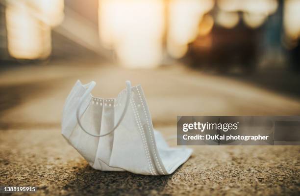 surgical mask lying on the street - coronavirus mask stockfoto's en -beelden