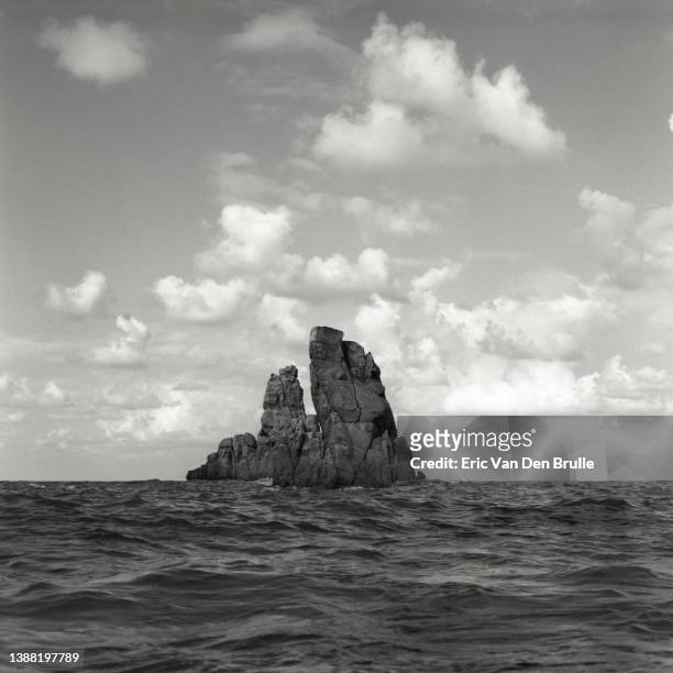 rock formation rising out of the sea - eric van den brulle stock pictures, royalty-free photos & images