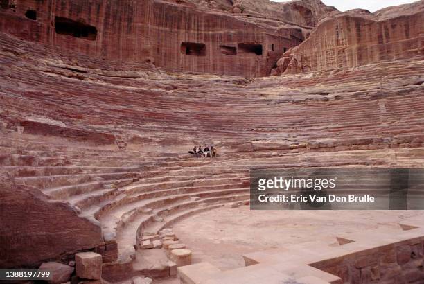 tourist sitting in amphitheater in petra, jordan - eric van den brulle stock pictures, royalty-free photos & images