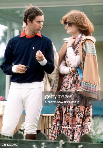 Prince Charles, Prince of Wales, wearing a navy blue Ralph Lauren jumper and white jodhpurs, talks to his girlfriend and sister of Lady Diana...