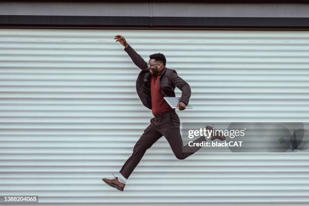 happy young businessman jumping - business rivalry stock pictures, royalty-free photos & images