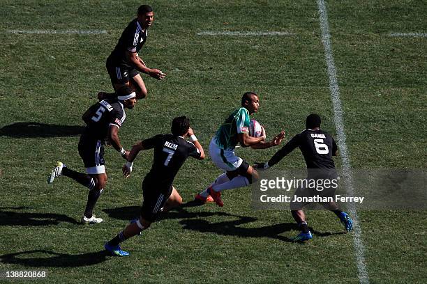 Cornal Hendricks of South Africa runs through Lote Raikabula, Bryce Heem and Tomasi Cama of New Zealand during the Cup Semi Final on day three of the...