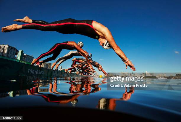 Phillip Seidler of Namibia, Jordan Wilimovsky of the United States and Florian Wellbrock of Germany dive into hot water of Tokyo Bay at the start of...