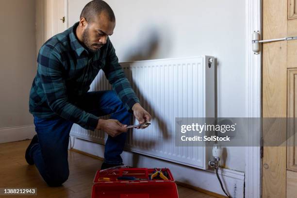 maintaining a radiator - plumber man stockfoto's en -beelden