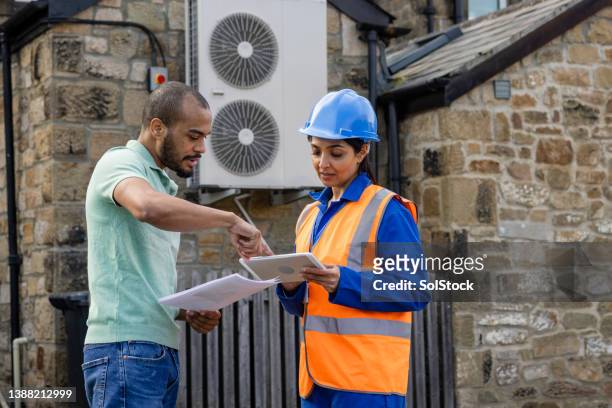 engineer working on an air source heat pump - power of print media stock pictures, royalty-free photos & images