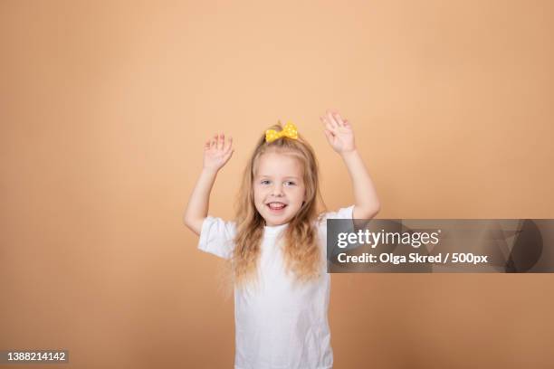 adorable blonde little girl in white t-shirt on brown - yellow - charming stockfoto's en -beelden