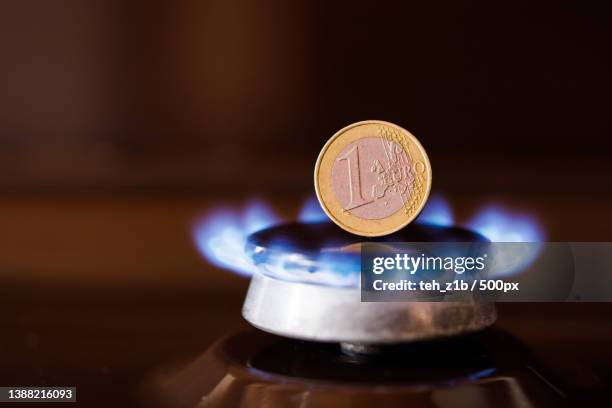 gas stove burner with one euro coin standing vertically on top - burner stove top 個照片及圖片檔