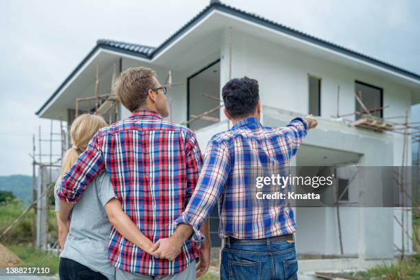 rear view of love triangle couple looking to house building. - hands behind back stock photos et images de collection