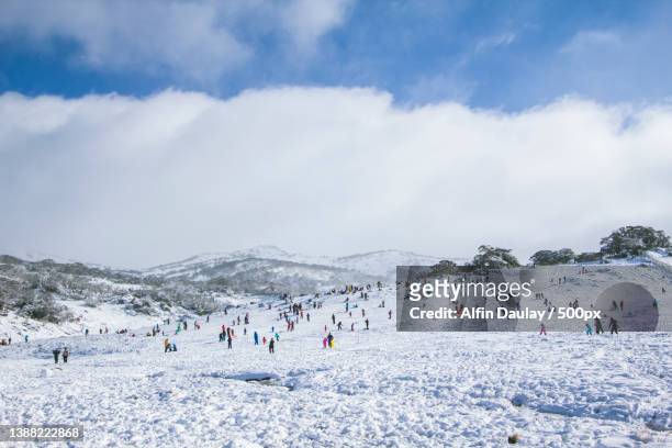 colorful playground,people skiing on snowcapped mountain against sky,kosciuszko national park,new south wales,australia - winter skiing australia stock pictures, royalty-free photos & images