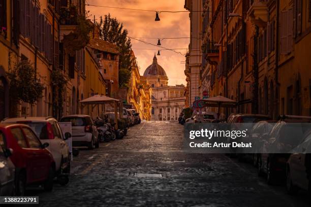dramatic light in the streets of rome city with church dome. - ancient rome stock-fotos und bilder