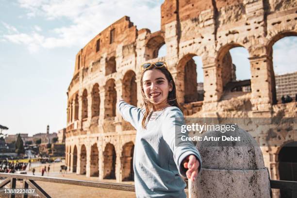 happy teenage girl visiting the colosseum monument in rome. - rome italy ストックフォトと画像