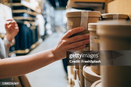 A Close Up Shot Of An Anonymous Caucasian Woman In A Shop Holding A Biodegradable Package Of Some Product Deciding Whether To Buy It Or Not A Close Up Shot Of An Anonymous Caucasian Woman In A Shop Holding A Biodegradable Package Of Some Product Deciding Whether To Buy It Or Not