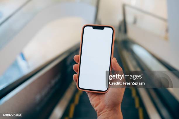 eine nicht erkennbare person, die ihr telefon benutzt, während sie auf der u-bahn-rolltreppe steht - escalator stock-fotos und bilder