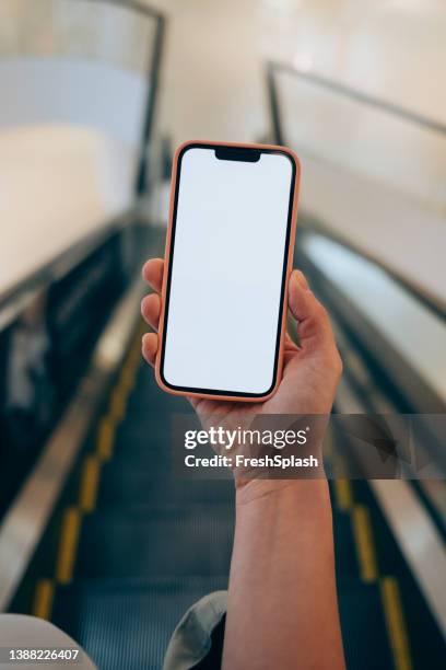 eine anonyme kaukasische person, die ihr smartphone überprüft, während sie sich auf einer unterirdischen rolltreppe befindet - smartphone im zug stock-fotos und bilder