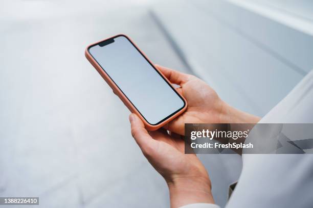 an anonymous caucasian individual checking his pink smartphone - holding iphone screen stock pictures, royalty-free photos & images