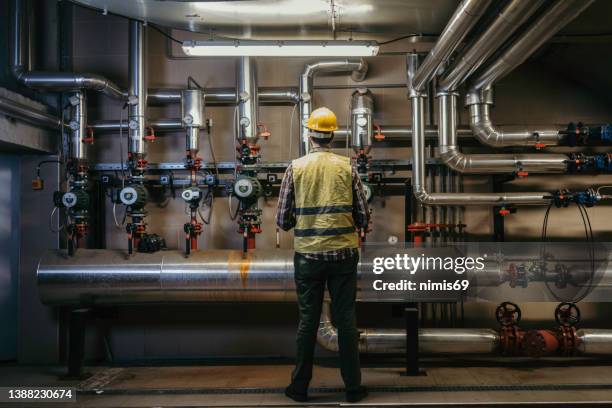 engenheiro estacionário em trabalho com suporte técnico - engenheiro de aquecimento - fotografias e filmes do acervo