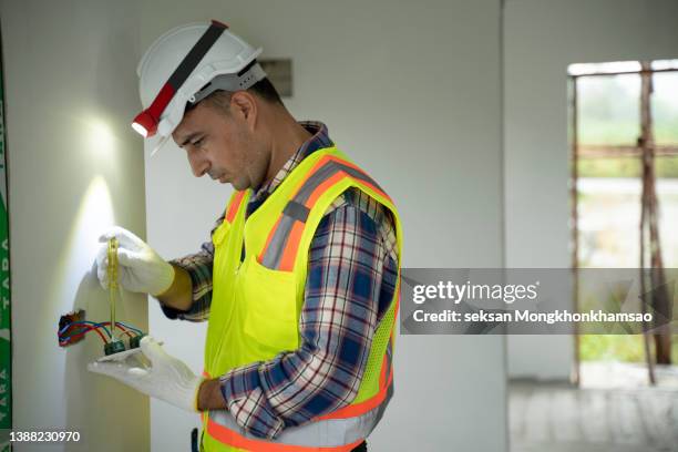 electrician prepares the installation of electrical wiring in the renovation of a home - power line repair stock pictures, royalty-free photos & images