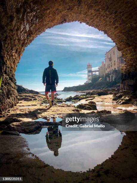 rear view of man waling under the bridge at santa marta lighthouse - lisbon people stock pictures, royalty-free photos & images