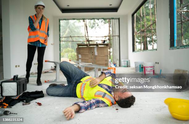 woman found man worker lying unconscious on the floor at the construction site. - casualty stock pictures, royalty-free photos & images